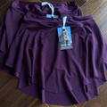 Purple skirt with a tag on a wooden floor